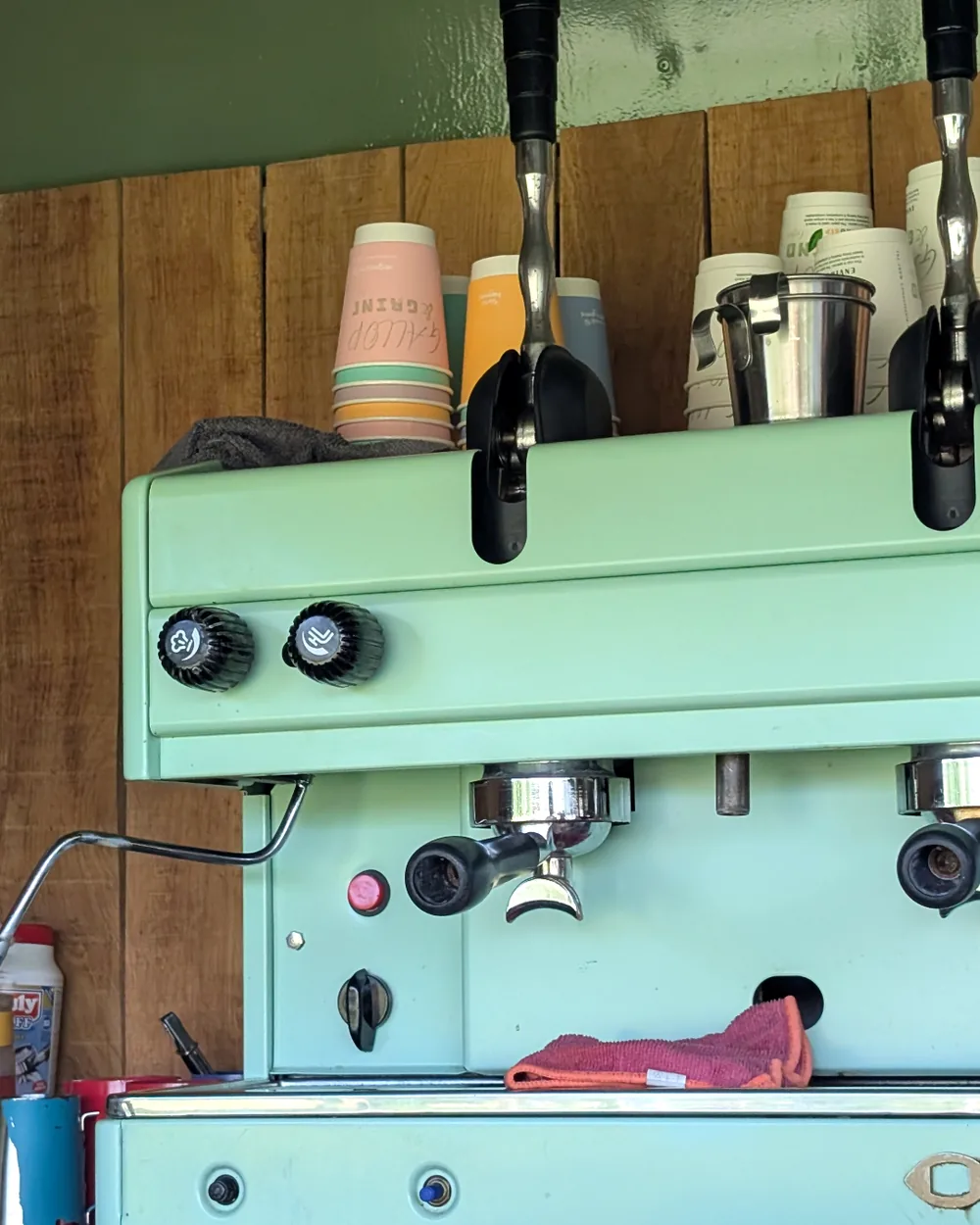 Close view of the restored sage-green Astoria lever espresso machine and group heads inside the horsebox