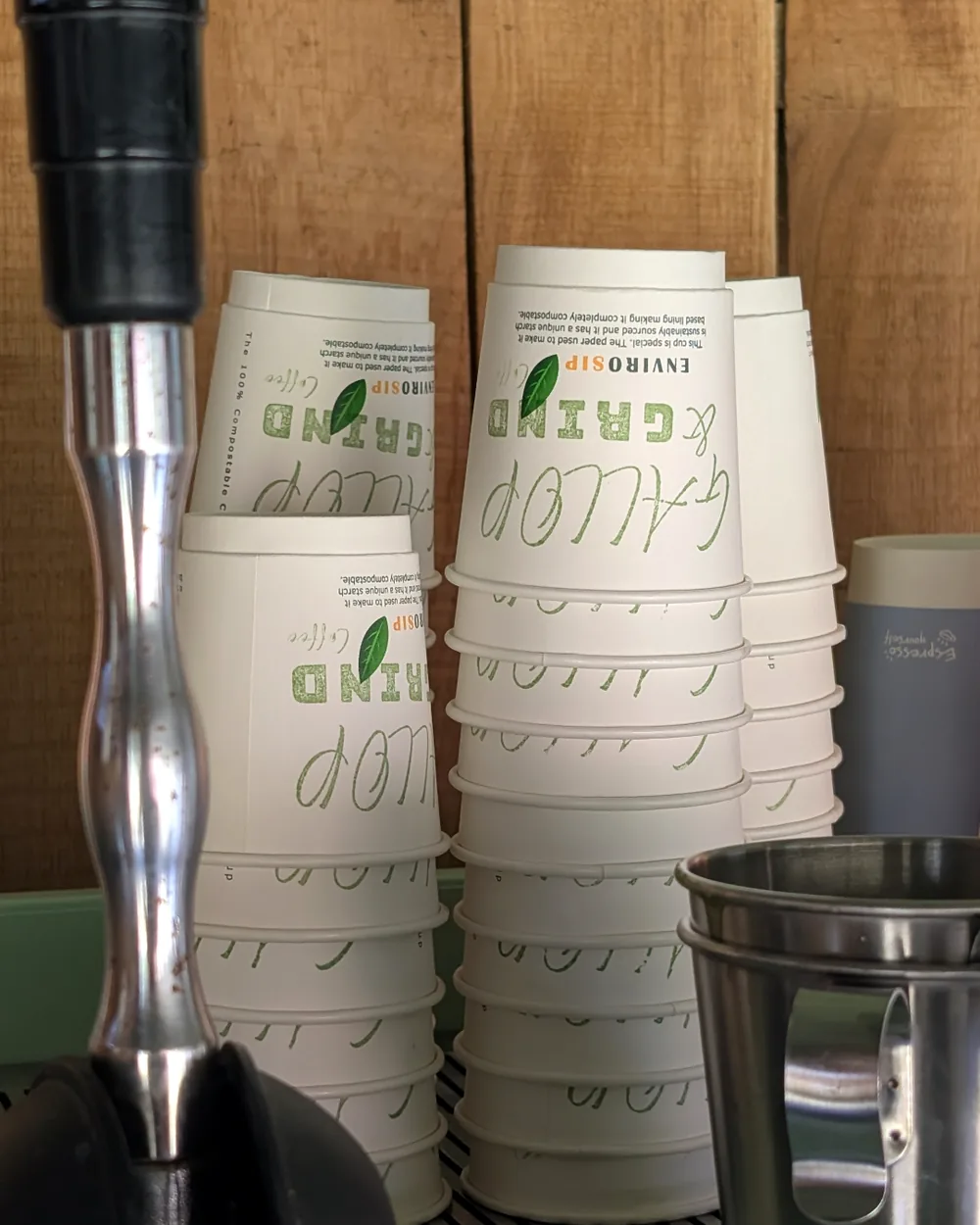 Stacks of Gallop & Grind branded compostable cups ready for service at the hatch