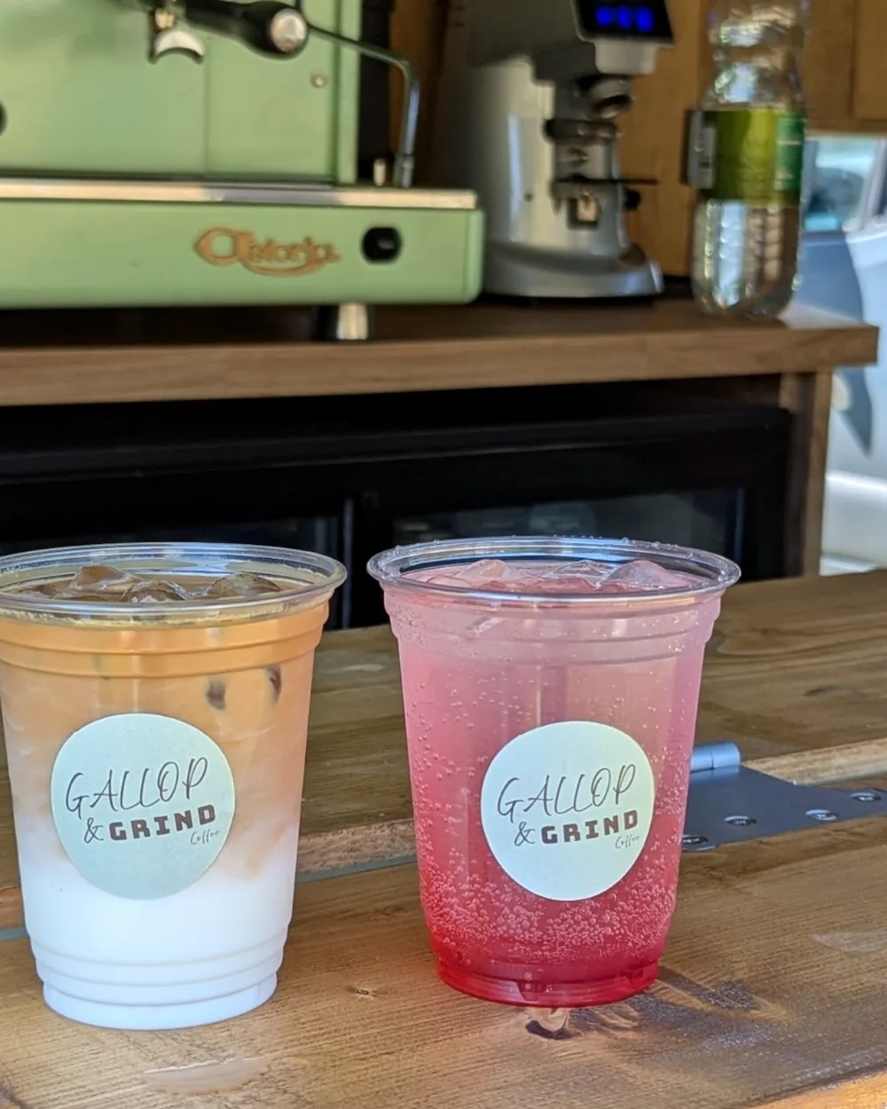 Two iced speciality coffees in Gallop & Grind branded cups on the serving hatch